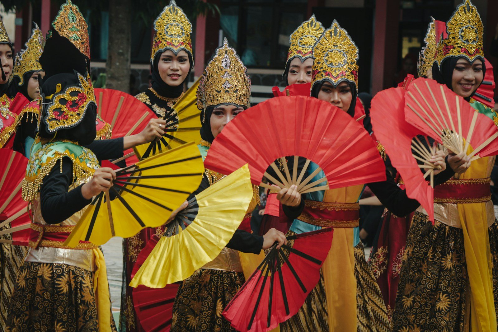 Women in colorful traditional attire holding fans