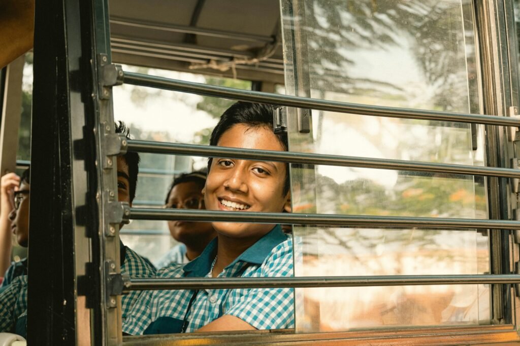 a man is smiling as he looks out the window of a bus